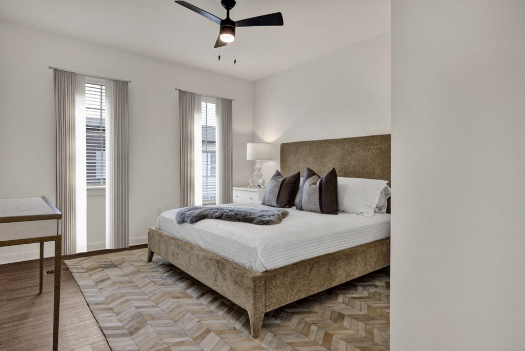 A bedroom with a large bed and a ceiling fan at West Row Townhomes and at West Row Townhomes at West Row Lofts and Townhomes in Birmingham, AL